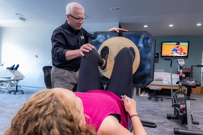physical therapist works with patient knee